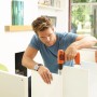 Uomo che fora un mobile bianco con avvitatore a batteria Black+Decker BDCD8.