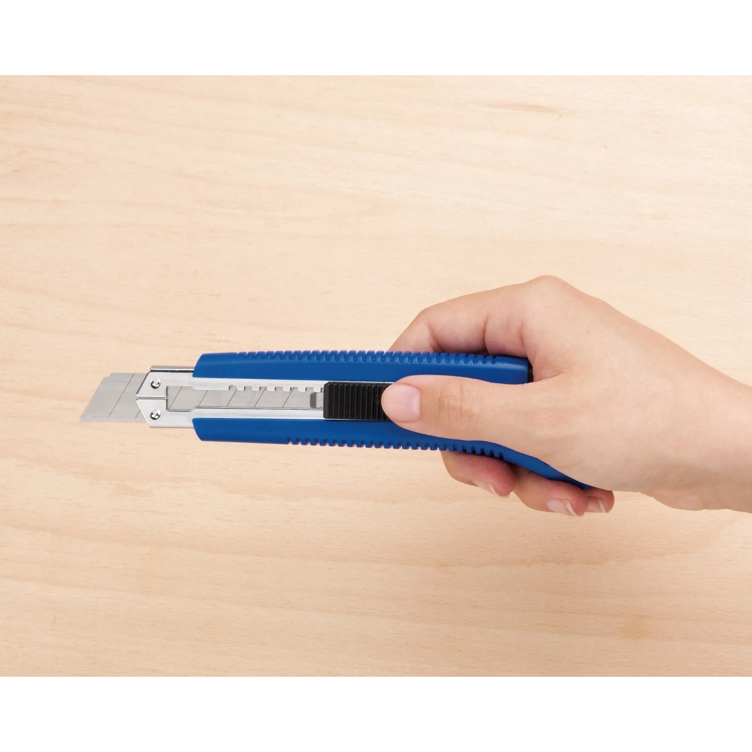 Mano che tiene un cutter LUX Classic 100 mm blu. Coltello con corpo in metallo e blocco lama.
