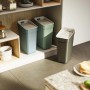 Tre pattumiere t.b.t. in blu, verde e grigio in cucina.