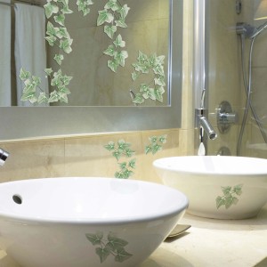 Adesivi da parete t.b.t. con motivo edera in bagno su specchio e lavandino.