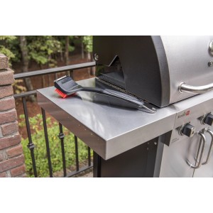 Spazzola per griglia Char-Broil Cool Clean Premium su un tavolo da grill. Utensile per griglia con raschietto e gancio.
