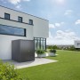 Armadio da esterno Biohort Large, grigio scuro metallizzato, davanti a casa moderna su prato.