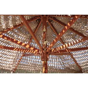 Dettaglio dell'ombrellone a braccio t.b.t. con struttura in legno e copertura intrecciata.