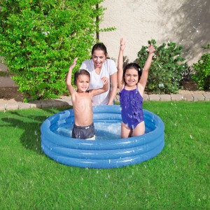 Piscina gonfiabile blu con bambini e adulto che giocano in giardino.
