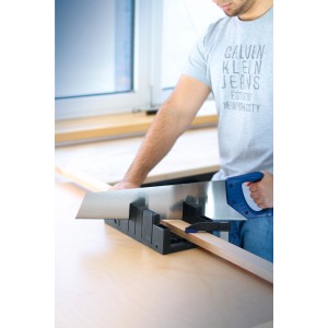 Uomo che sega legno con cassetta per tronchi LUX 300 mm e seghetto. Impostazioni angolari fissabili.