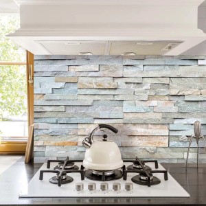 Pannello paraschizzi cucina con motivo pietra come rivestimento dietro il piano cottura.