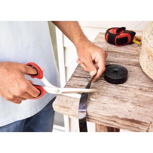 Taglio del nastro a strappo per tenda magnetica tesa con le forbici per l'installazione.