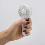 Mano che tiene un ventilatore portatile bianco t.b.t.