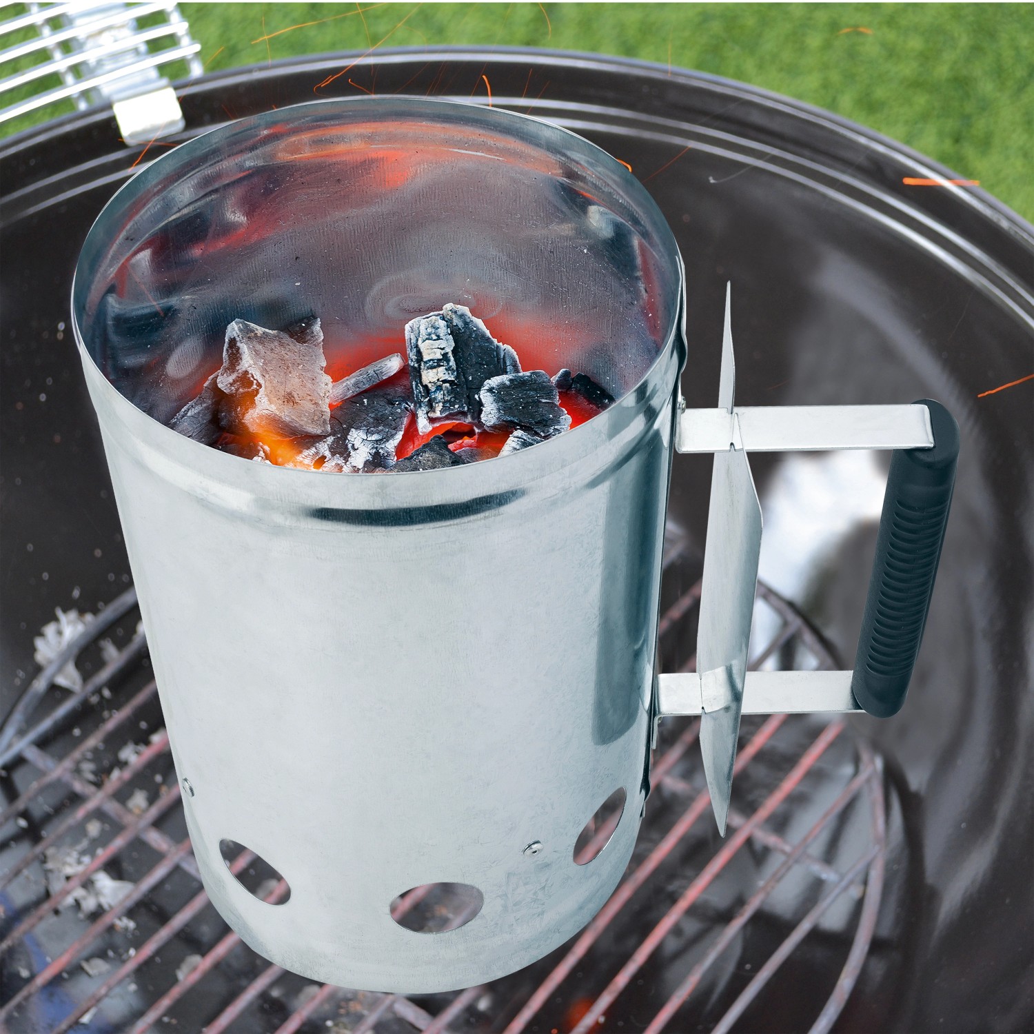 Accendifuoco in metallo con carboni ardenti e manico in plastica per barbecue.