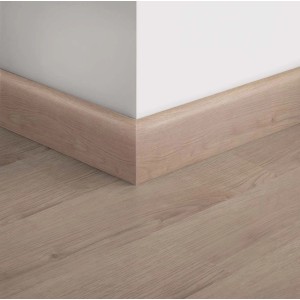 Battiscopa color legno su parete bianca e pavimento in legno coordinato.