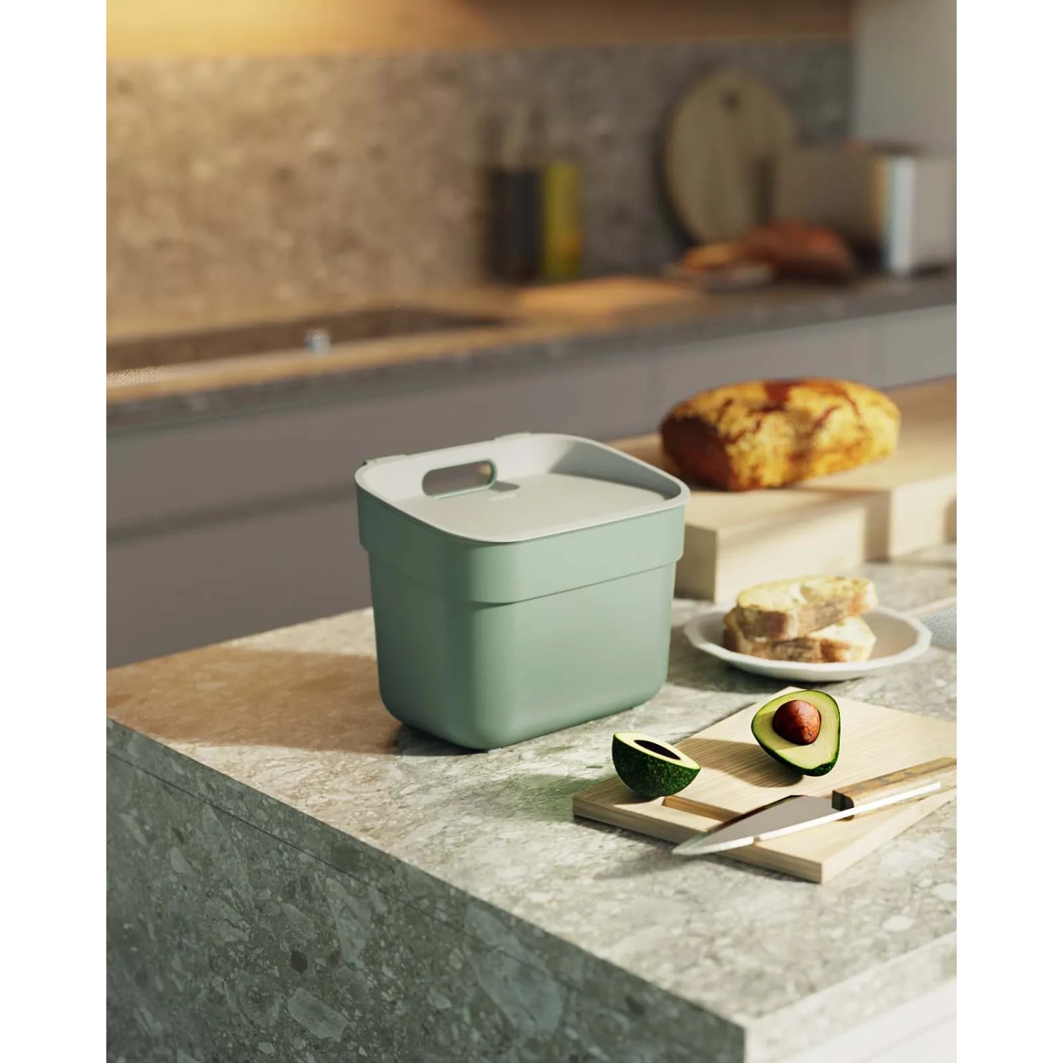 Cestino t.b.t. verde menta su un bancone da cucina con avocado e pane.