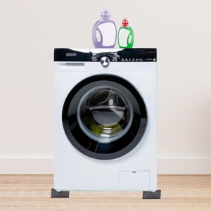 Lavatrice con feltrini t.b.t. e detersivo su pavimento in legno.