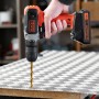 Trapano avvitatore a batteria Black+Decker BCD001C1 con batteria mentre fora una piastra.