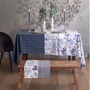 Tavolo con tovaglia t.b.t., metà blu a motivi, metà con motivo floreale.