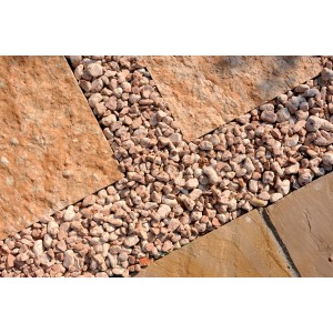 Primo piano di ghiaia decorativa t.b.t. tra le pietre di pavimentazione. Ideale per vialetti e decorazioni.