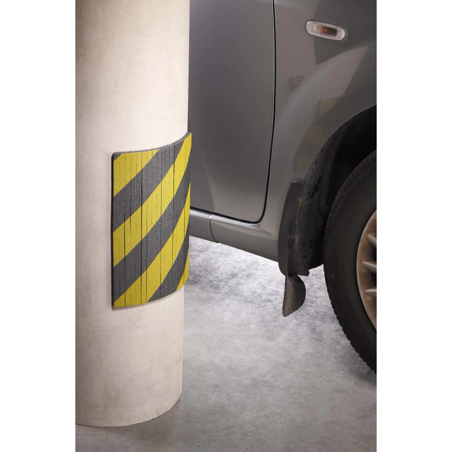 t.b.t. protezione antiurto gialla/nera su pilastro in garage, auto sullo sfondo.