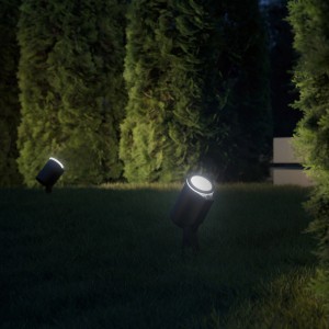 Due faretti Steinel LED Spot Garden SC antracite illuminano prato e piante in giardino.