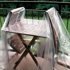 Pellicola protettiva trasparente su tavolo e sedie da giardino. Protezione dagli agenti atmosferici.