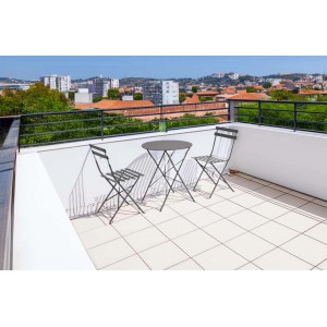 Set di mobili da giardino grigio con tavolo e due sedie su una terrazza panoramica.