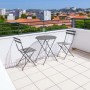 Set di mobili da giardino grigio con tavolo e due sedie su una terrazza panoramica.