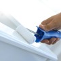 Rullo in feltro LUX 25 cm mentre vernicia una superficie bianca. Rullo per pittura con manico blu.