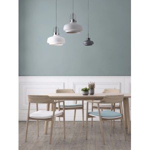 Sala da pranzo con tavolo, sedie e tre lampade a sospensione in bianco e grigio.