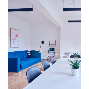 Stanza luminosa con divano blu, tavolo e decorazioni. Ideale per pitture per interni bianche.