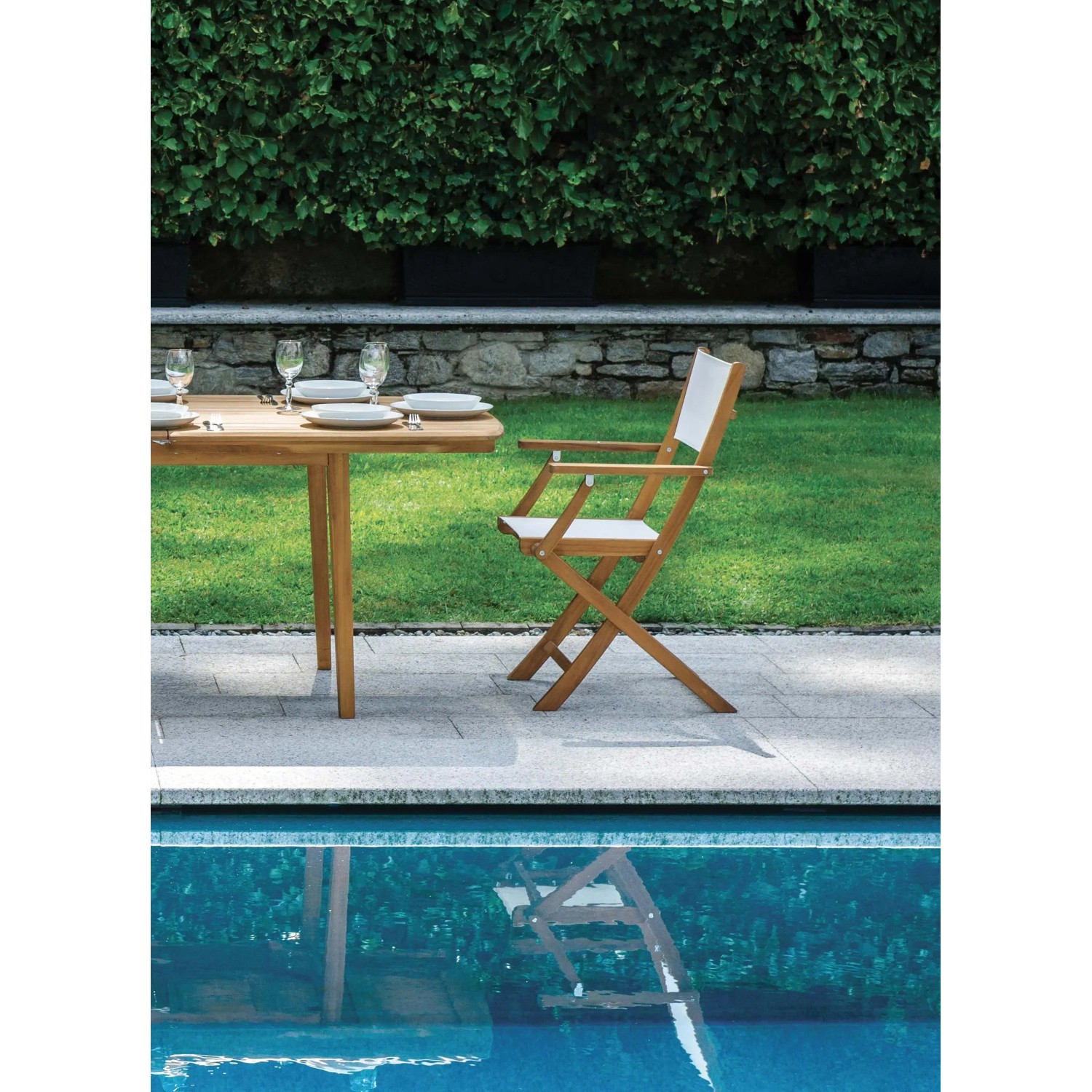 Tavolo e sedia da giardino t.b.t. in legno e tessuto in un ambiente da giardino.