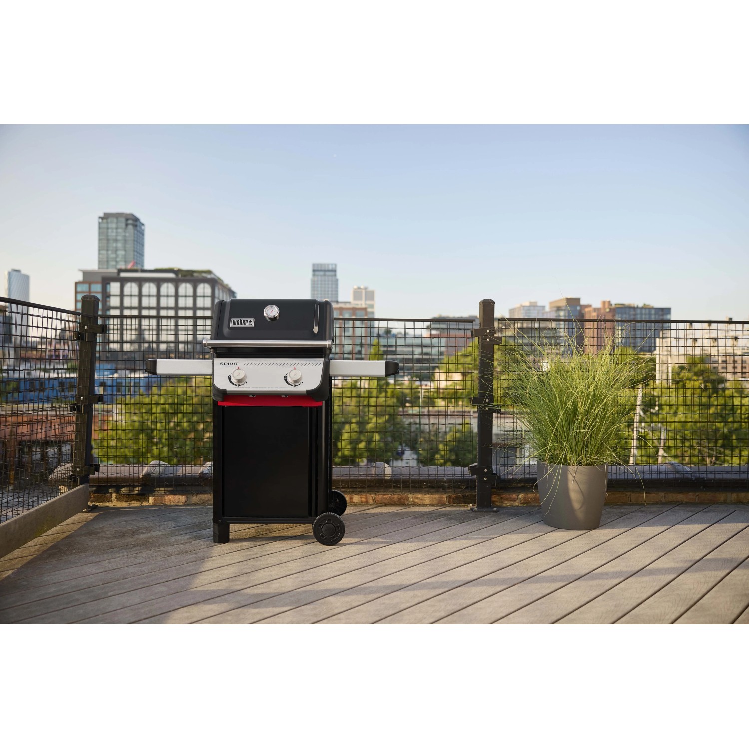 Barbecue a gas nero su una terrazza panoramica con vista sulla città. Barbecue per grigliate rilassanti.