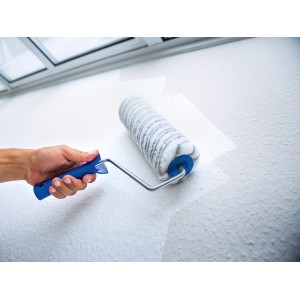 Rullo a dispersione LUX 18 cm mentre dipinge una parete. Rullo con manico blu e rivestimento grigio e bianco.