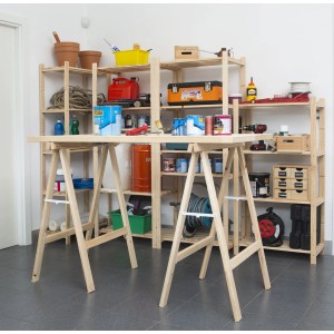 Officina con due cavalletti come struttura del tavolo e scaffali sullo sfondo.