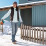Donna che usa uno spargitore Gardena Kleinstreuer S turchese in inverno per spargere sale.