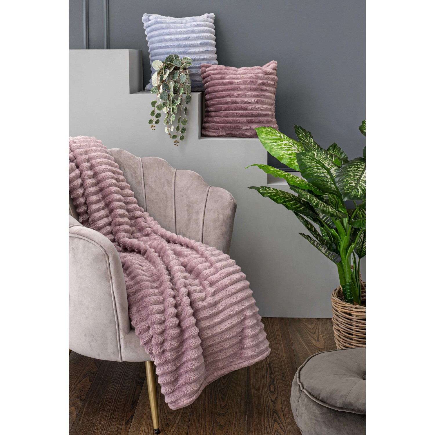 Coperta rosa t.b.t. su poltrona, con cuscini. Scena accogliente del soggiorno.