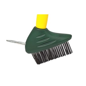 Primo piano di una piccola spazzola da giardino con manico giallo e testina verde.
