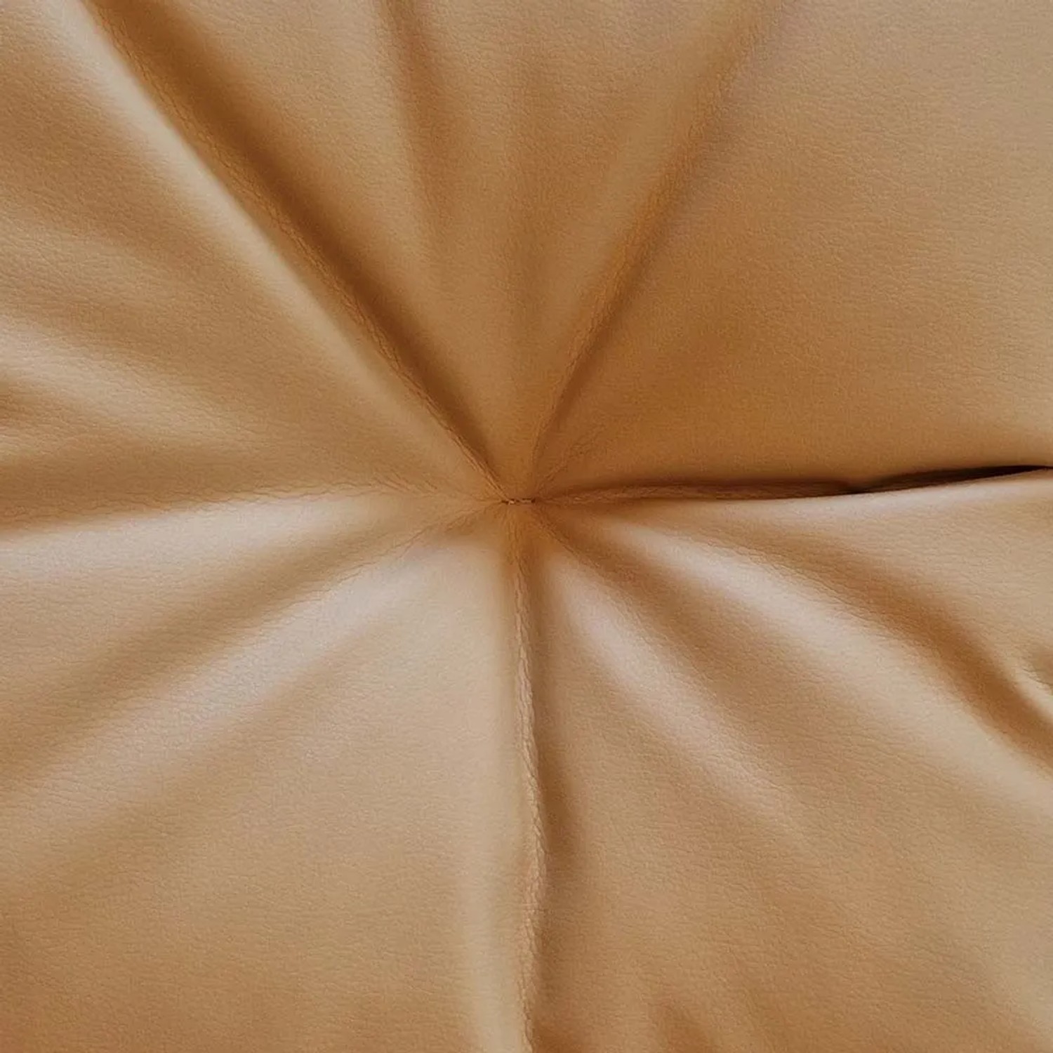 Dettaglio di un cuscino beige trapuntato.