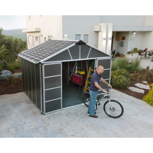 Casetta da giardino grigia Palram Canopia Yukon 3.3 x 2.7 m con uomo e bicicletta davanti alla porta aperta.