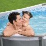 Piscina fuori terra ovale con uomo e bambina in acqua. Ideale per il divertimento in famiglia.