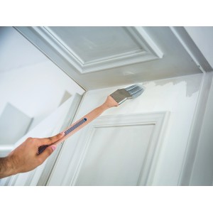 Pennello angolare LUX 50 mm mentre vernicia una porta. Pennello con manico in legno e setole sintetiche.