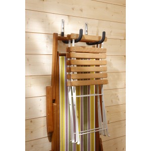 Sedia pieghevole con ganci a muro per riporla su parete in legno.
