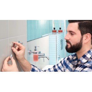 Uomo che installa un porta asciugamani t.b.t. in bagno.