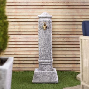 Fontana da giardino grigia con rubinetto in ottone per uso esterno.