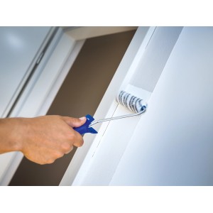 Rullo per dispersioni LUX 10 cm mentre dipinge una parete. Rullo a pelo corto.