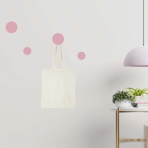 Appendiabiti t.b.t. con borsa di stoffa su parete con lampada e tavolo.