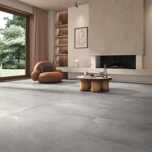 Gres porcellanato posato Urban Madreperla 119,8x119,8 cm in soggiorno con poltrona e camino.
