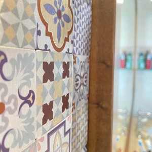 Piastrelle a mosaico con vari motivi nei toni del viola, marrone e beige.
