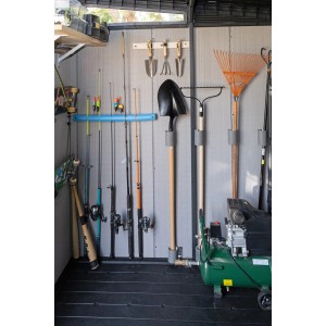 Vista interna di una casetta da giardino in plastica con attrezzi e attrezzatura da pesca sulla parete.