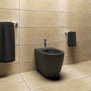 Bidet nero sospeso in un bagno moderno con asciugamani.