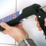 Pistola per cartucce LUX Comfort che applica silicone su piastrelle.