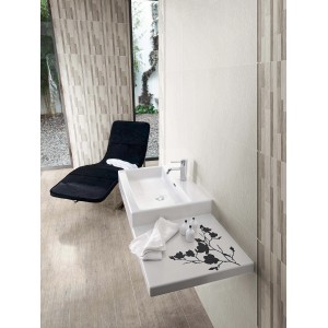 Bagno con piastrelle da rivestimento t.b.t. in beige e bianco, lavabo con decoro floreale.