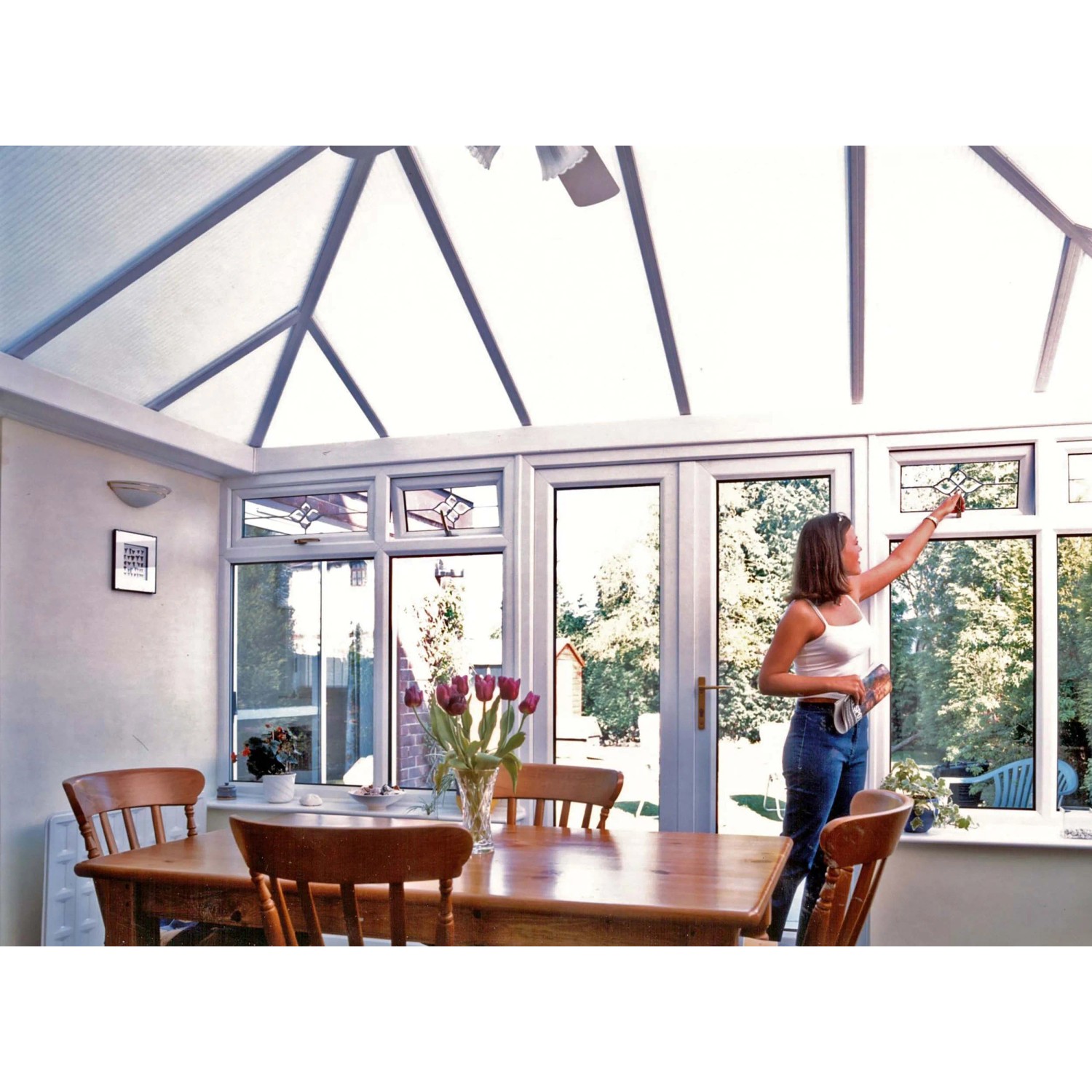 Donna pulisce veranda con lastre in plastica e alveolari t.b.t. come tetto.